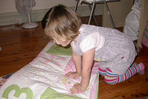 Isabelle opening her quilt